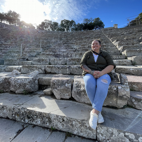 person sitting on the steps of an ampitheater