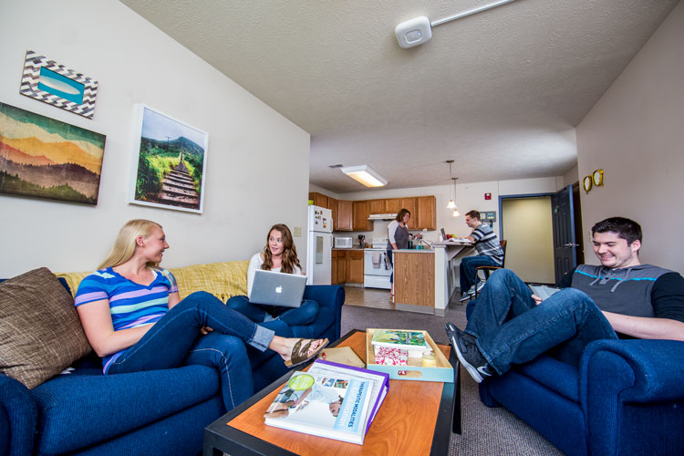 Student hanging out in the living room of their dorm.