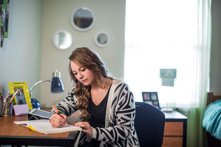 Student studying in her bedroom.