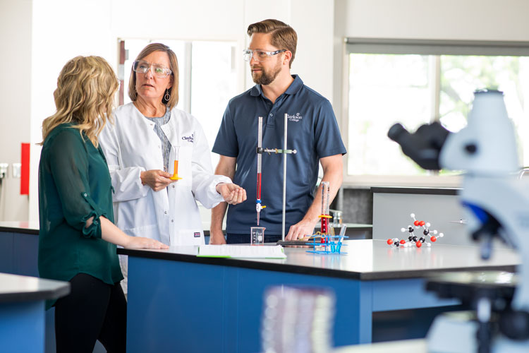 Two students with an instructor in the science lab